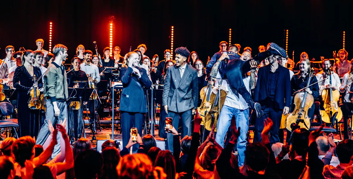 Artister og ungdomsorkester tar imot applaus på scenen under Red Bull Symphonic