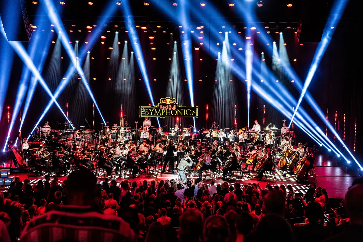 Symfoniorkester på scenen i blått lys foran fullsatt Peer Gynt-salen i Grieghallen