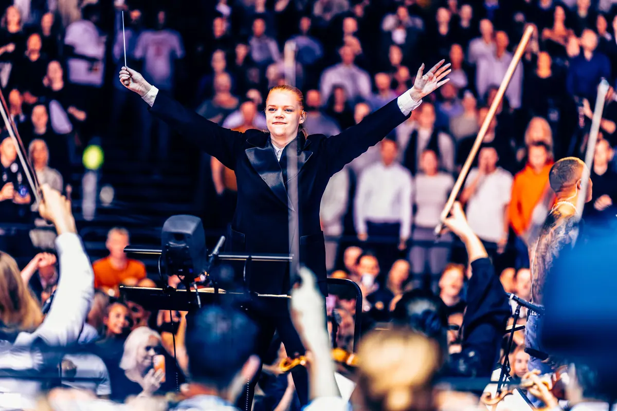 Dirigent med armene i været foran orkester og publikum under Red Bull Symphonic