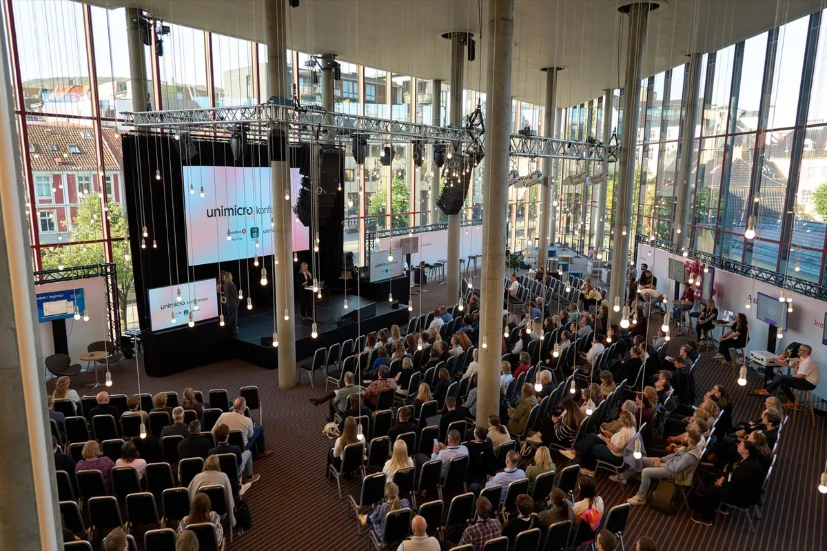 Oversikt over konferansesalen med glassvegger og publikum under Unimicro Byråkonferansen